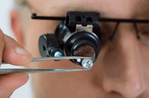 A diamond grading expert closely inspecting a diamond